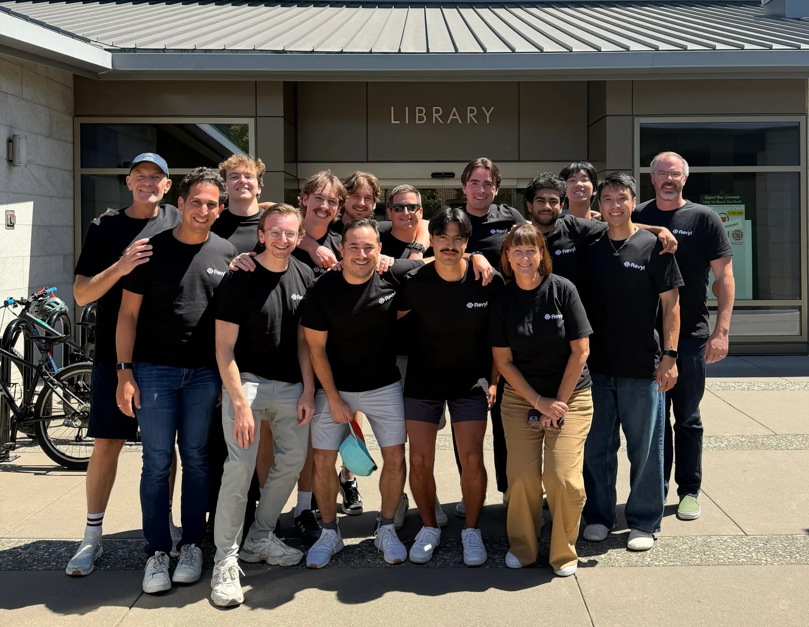 The Revyl team gathered outside a library wearing Revyl shirts